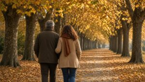 Coppia che cammina in un viale di platani d'autunno: il movimento come prima cura del mal di schiena.